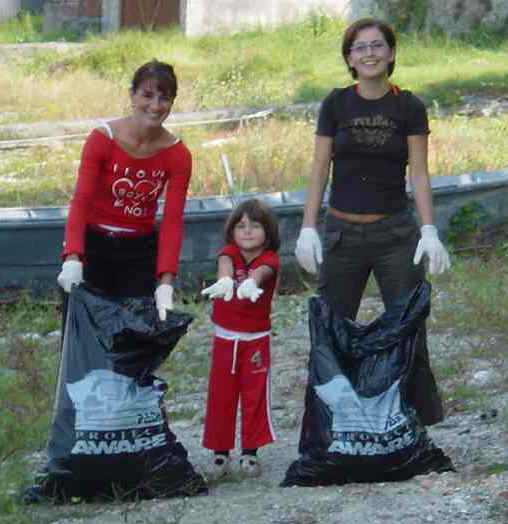 Betty, Sofia e Mariagrazie mostrano orgogliose i guanti utilizzati per le pulizie. Da notare i sacchi Project AWARE!