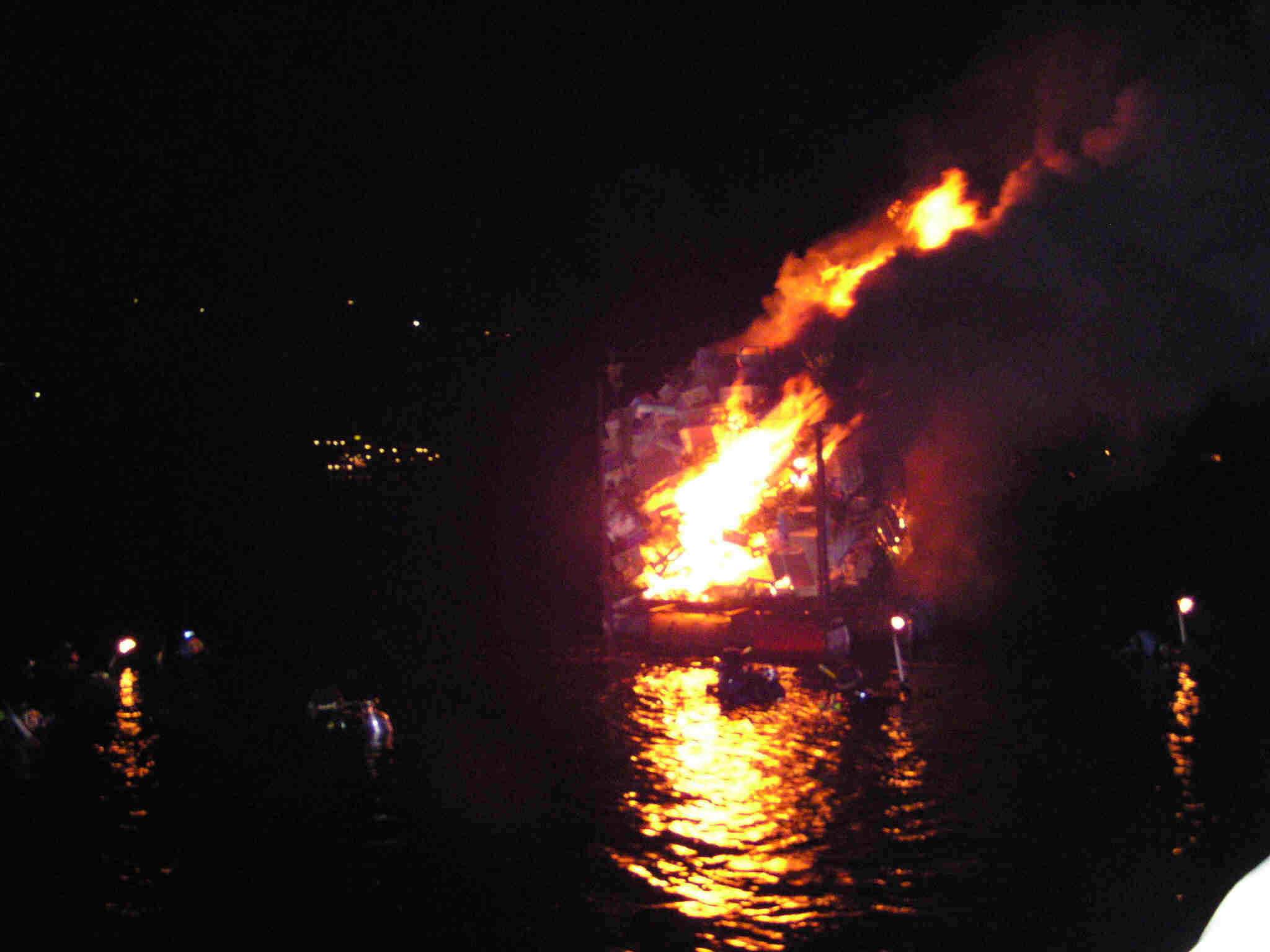 La catasta di legna galleggiante incendiata dai sub